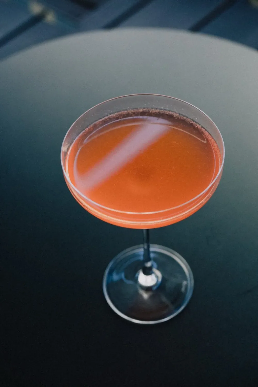 Cocktail rosado num copo de pé