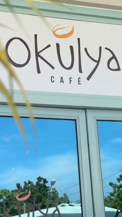 Letreiro do Okulya Café com janelas azuis